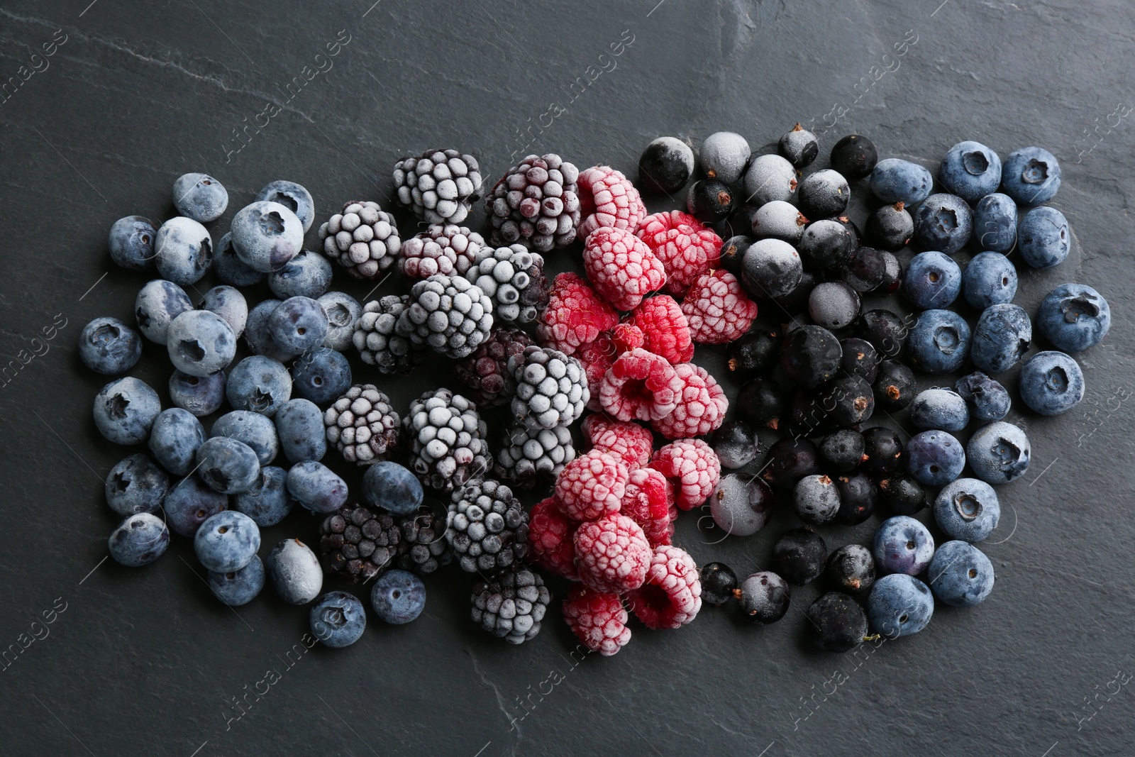 Photo of Mix of different frozen berries on black table, flat lay
