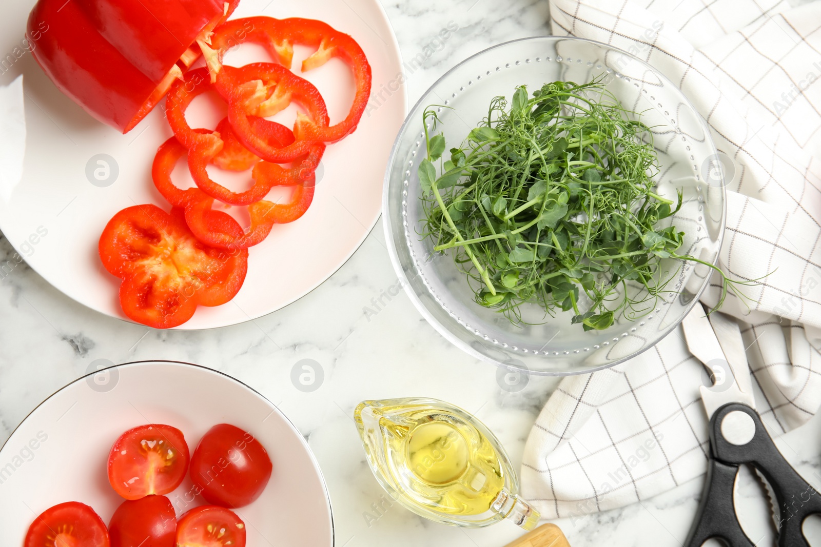 Photo of Fresh microgreen for tasty salad on white marble table, flat lay