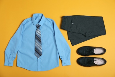 Flat lay composition with school uniform on yellow background