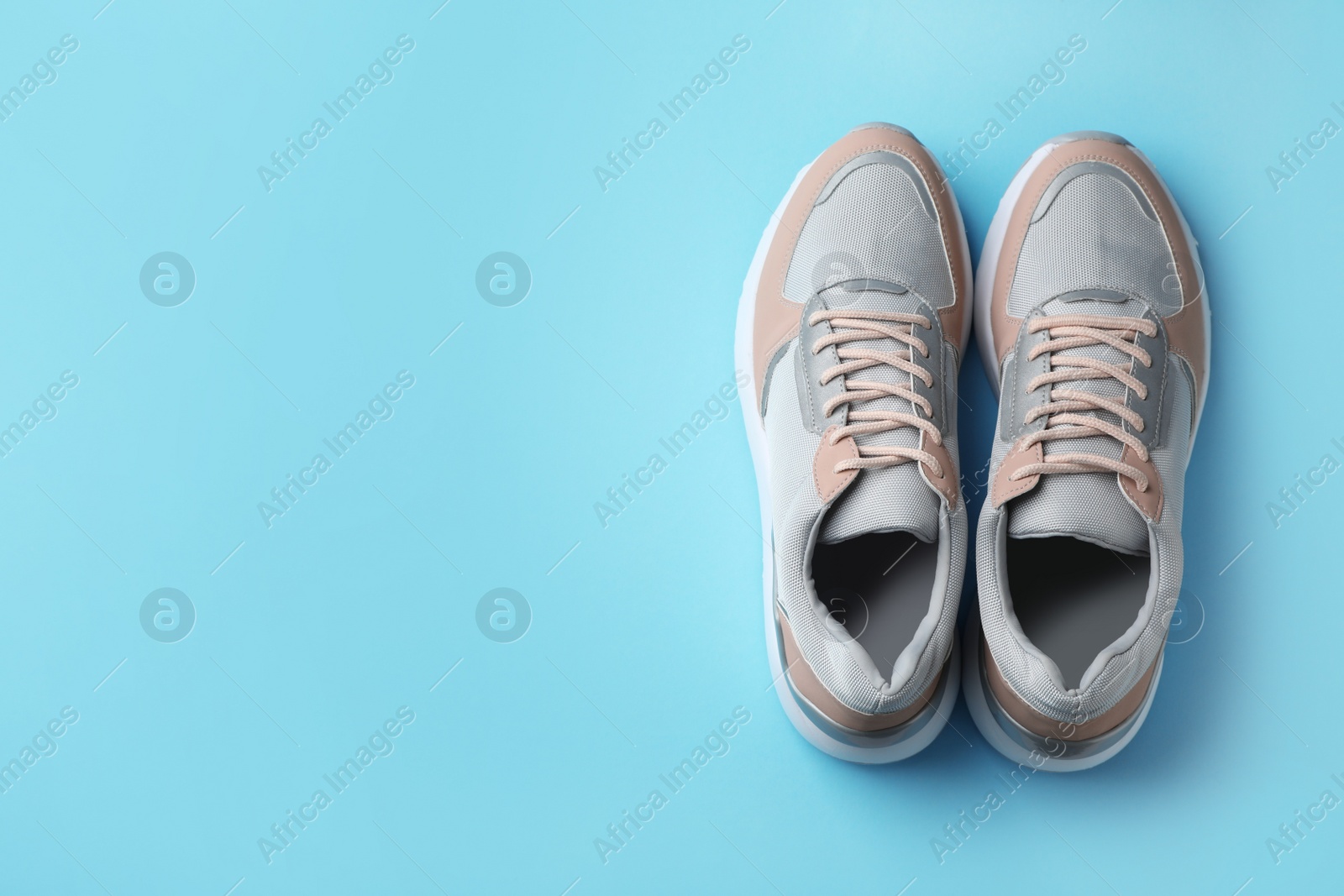 Photo of Pair of stylish sneakers on color background, top view. Space for text