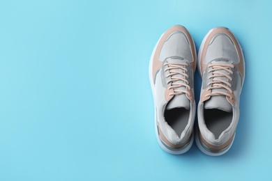 Photo of Pair of stylish sneakers on color background, top view. Space for text