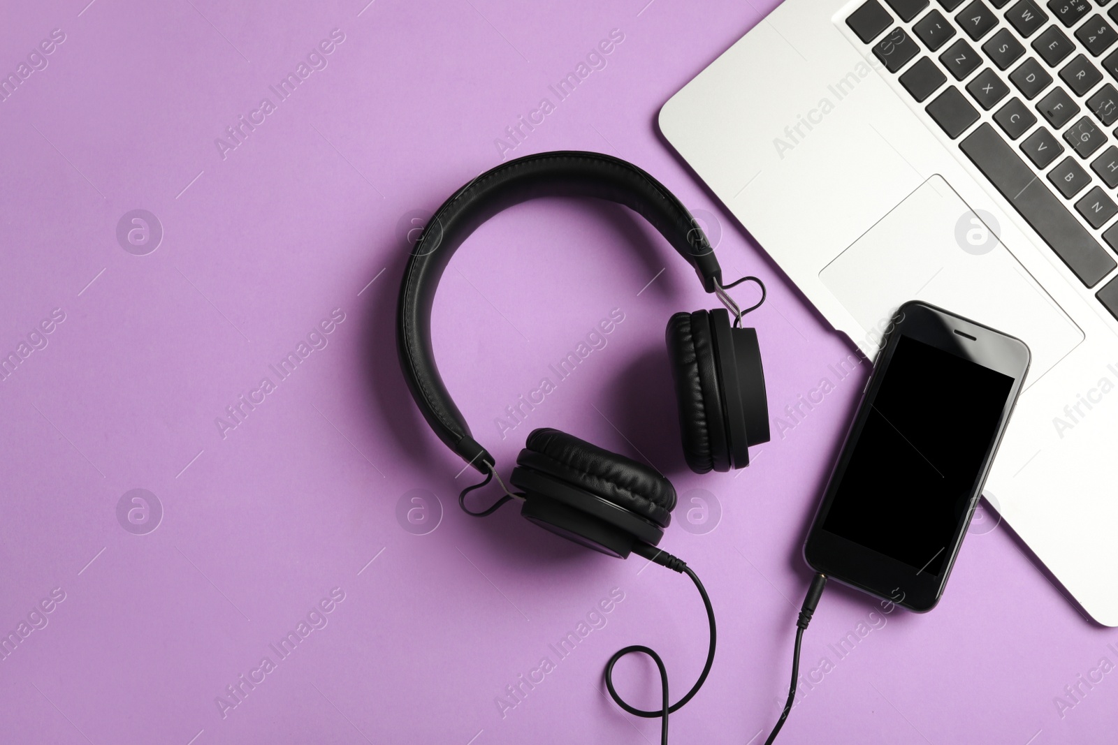 Photo of Modern headphones, phone and laptop on color background, flat lay. Space for text