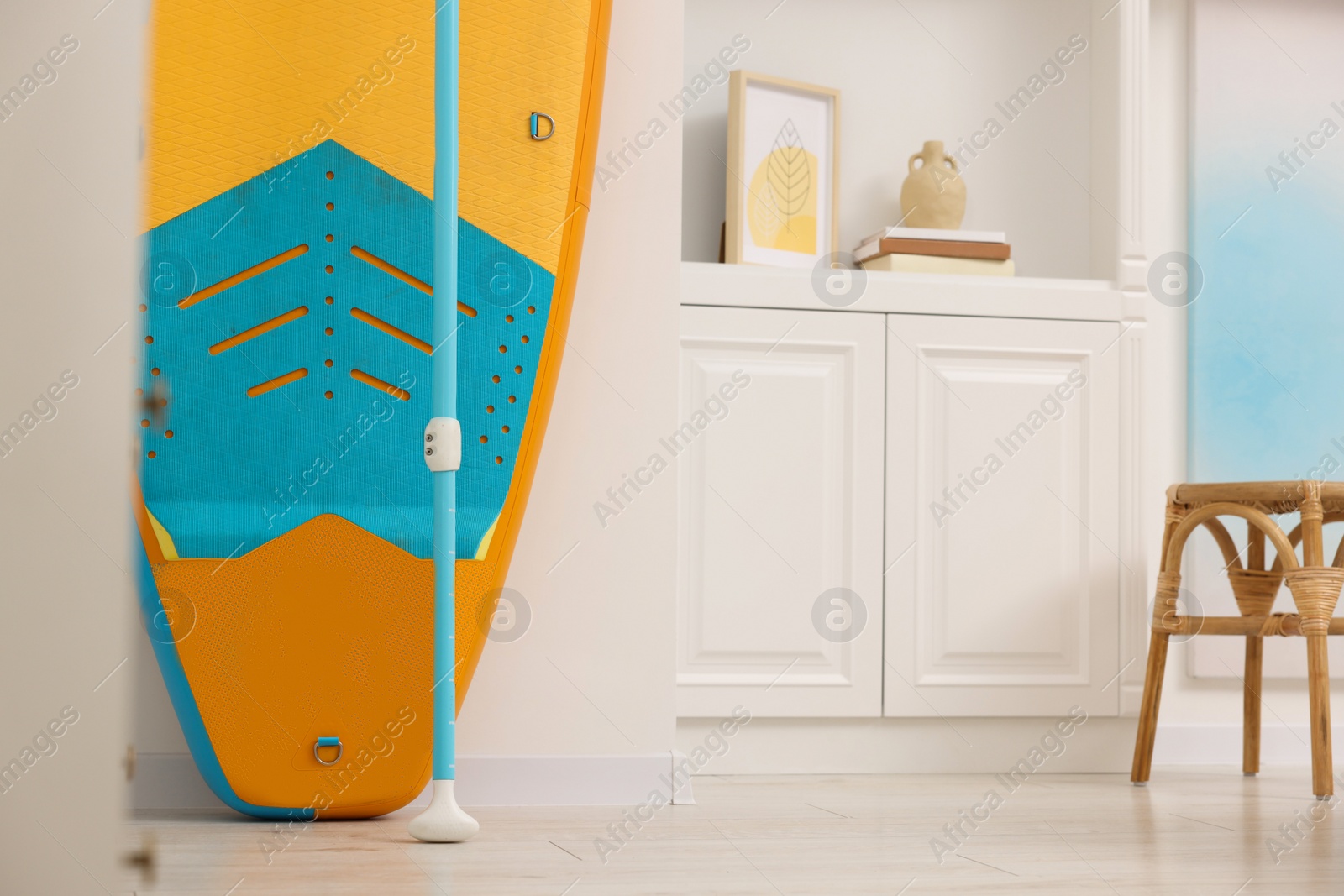 Photo of SUP board and furniture in room. Interior design