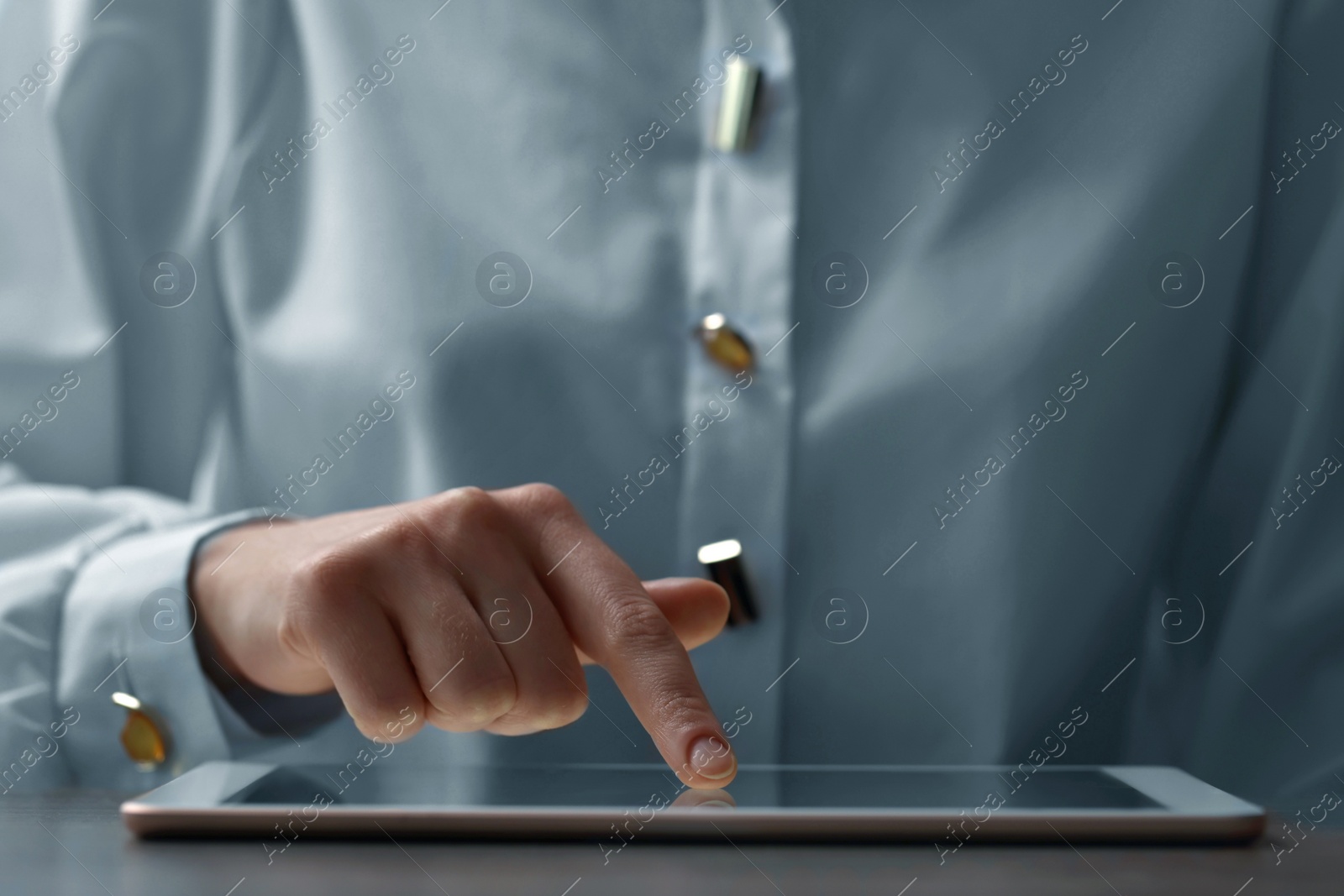 Photo of Closeup view of woman using modern tablet at table