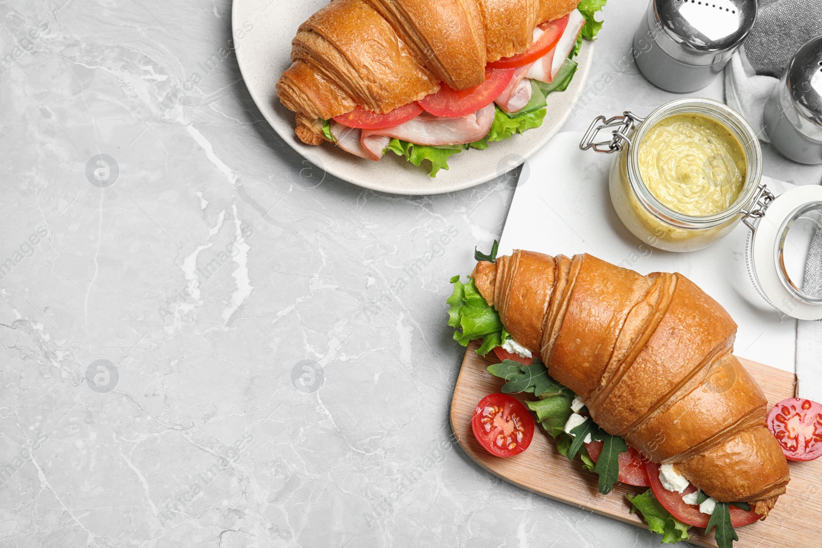 Photo of Flat lay composition with tasty croissant sandwich on light grey marble table. Space for text