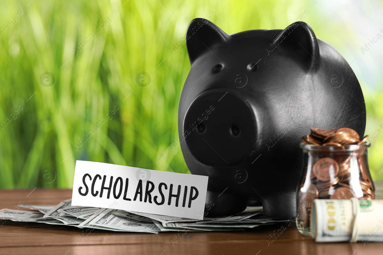 Photo of Scholarship concept. Glass jar with coins, dollar banknotes and piggy bank on wooden table