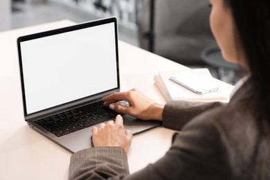 Woman using modern laptop at desk in office, closeup