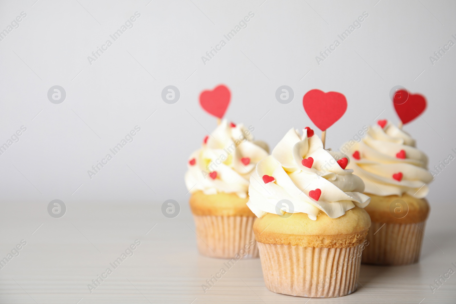 Photo of Tasty sweet cupcakes on white table, space for text. Happy Valentine's Day
