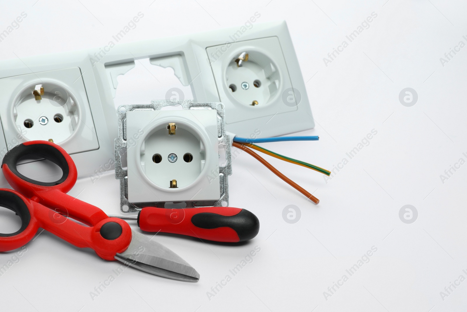 Photo of Set of sockets and electrician's tools on white background