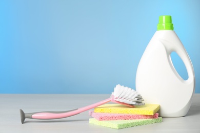 Photo of Bottle of cleaning product and supplies on light table. Space for text