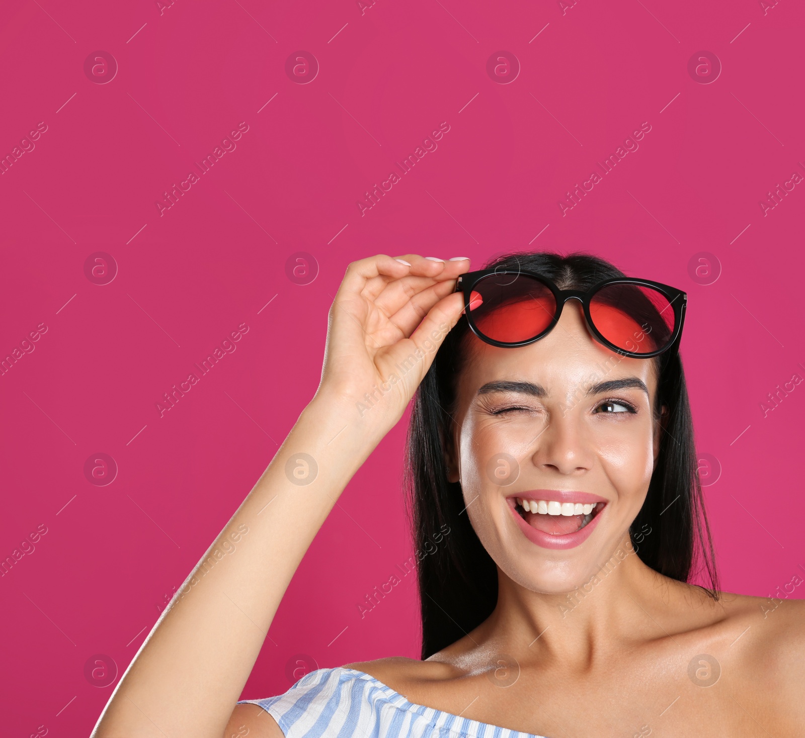 Photo of Beautiful woman wearing sunglasses on pink background