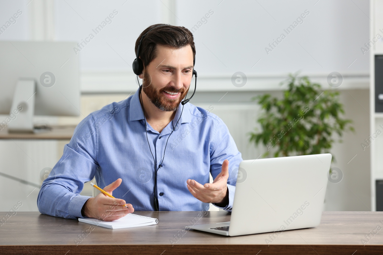 Photo of Hotline operator with headset working in office