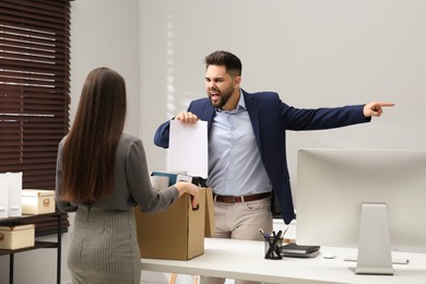 Photo of Boss dismissing young woman from work in office