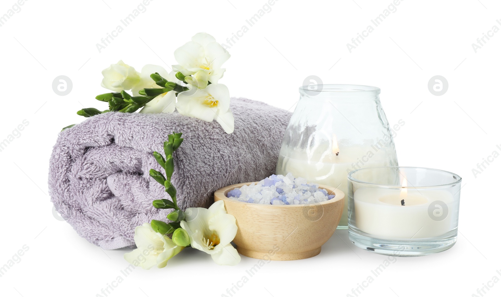 Photo of Spa composition. Towel, burning candles, sea salt and beautiful flowers on white background