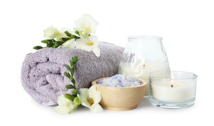 Photo of Spa composition. Towel, burning candles, sea salt and beautiful flowers on white background