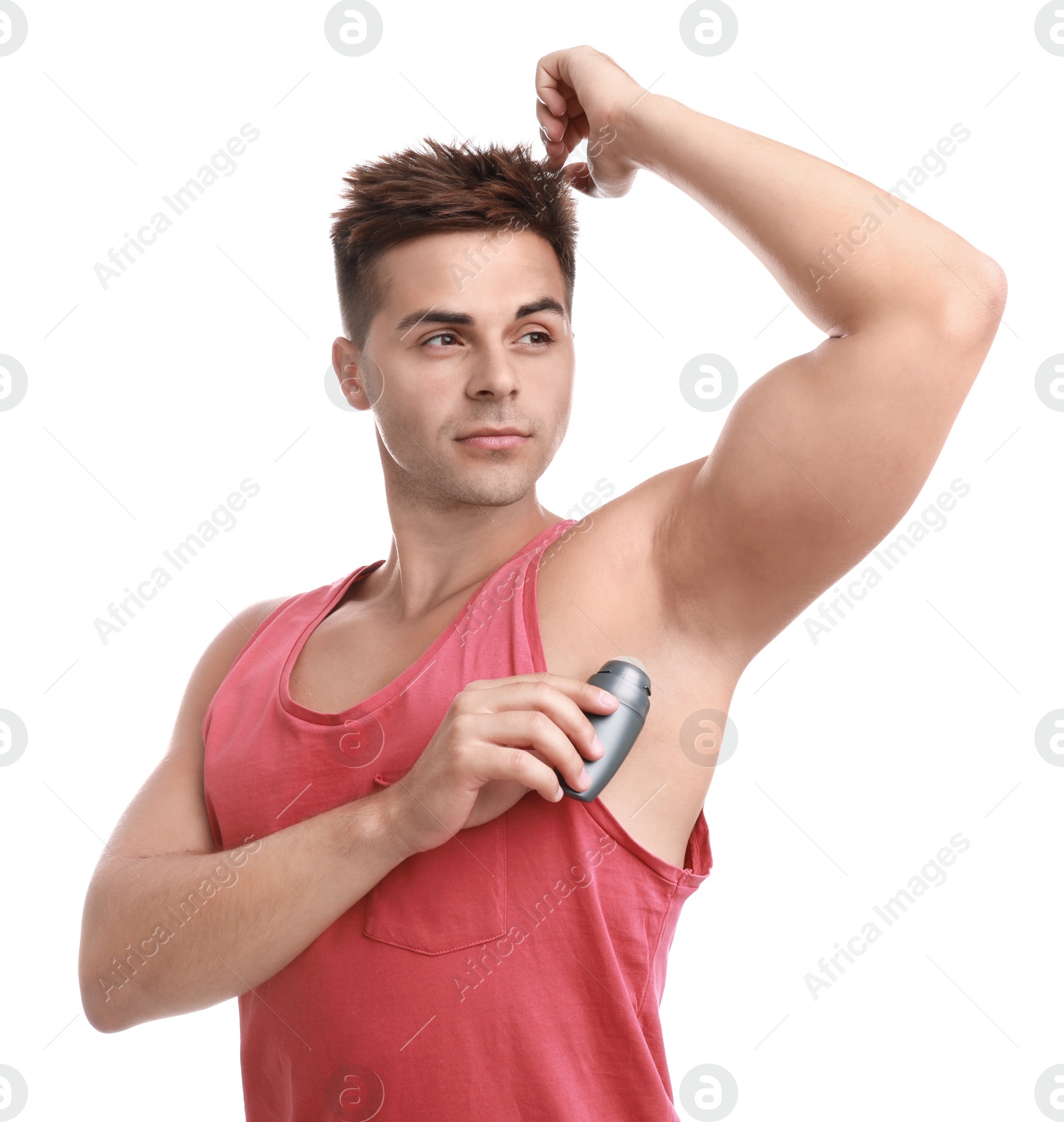 Photo of Young man applying deodorant to armpit on white background