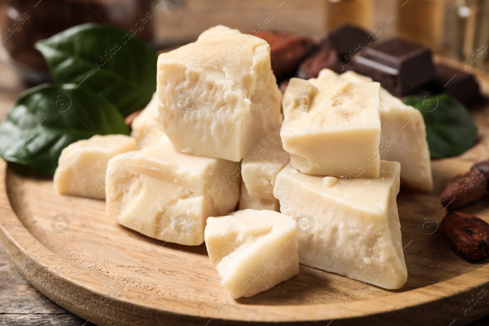 Photo of Organic cocoa butter on wooden table, closeup