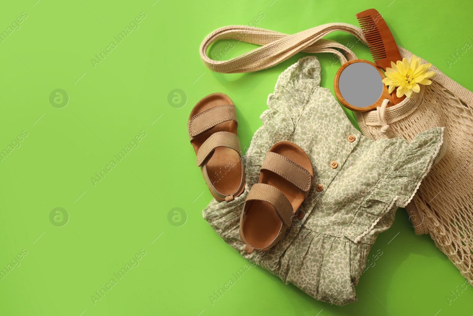 Photo of Stylish child clothes, shoes and accessories on green background, flat lay. Space for text