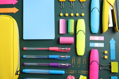 Flat lay composition with different school stationery on chalkboard surface