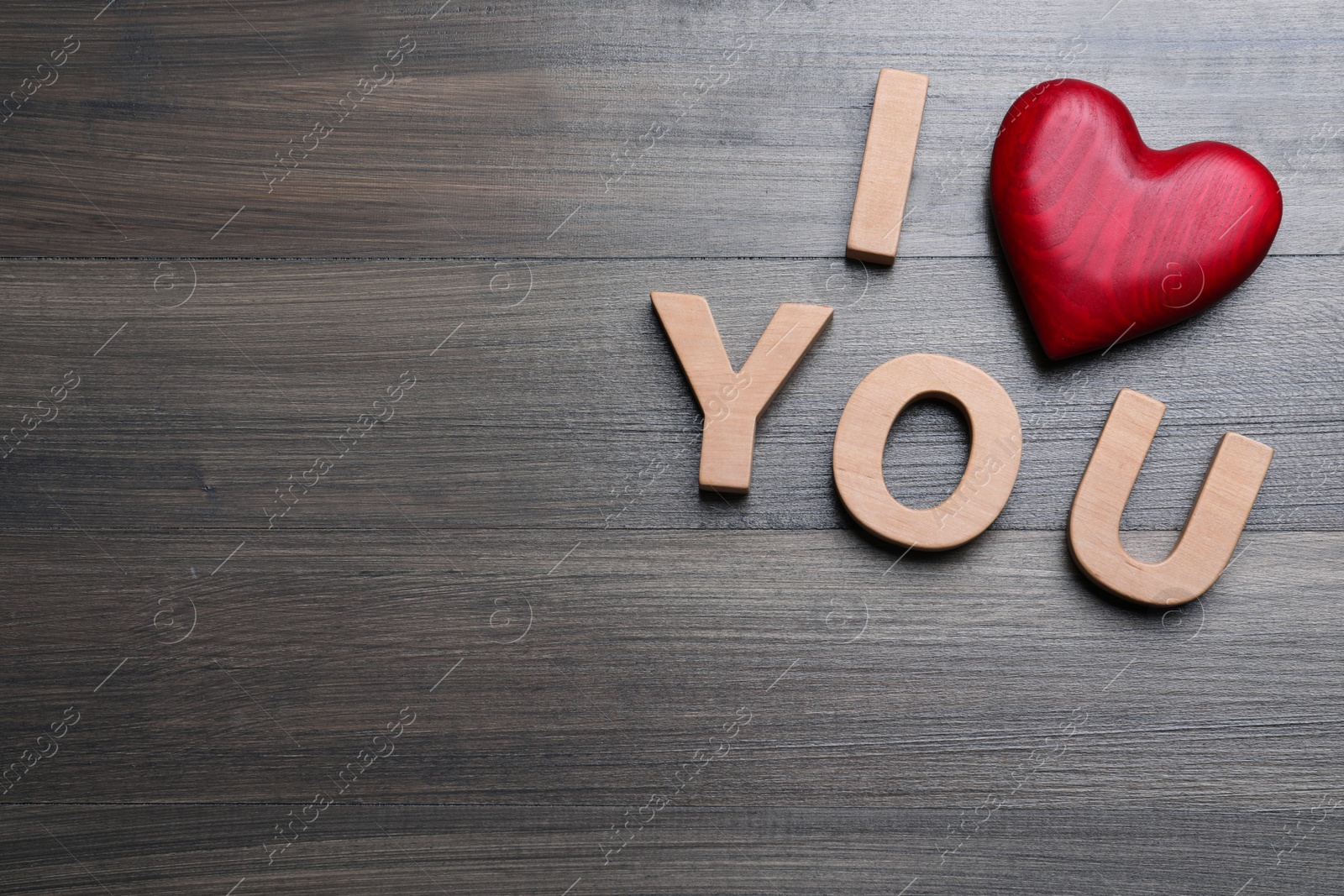 Photo of Phrase I Love You made of decorative heart and letters on wooden background, above view. Space for text