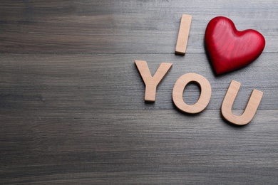 Phrase I Love You made of decorative heart and letters on wooden background, above view. Space for text