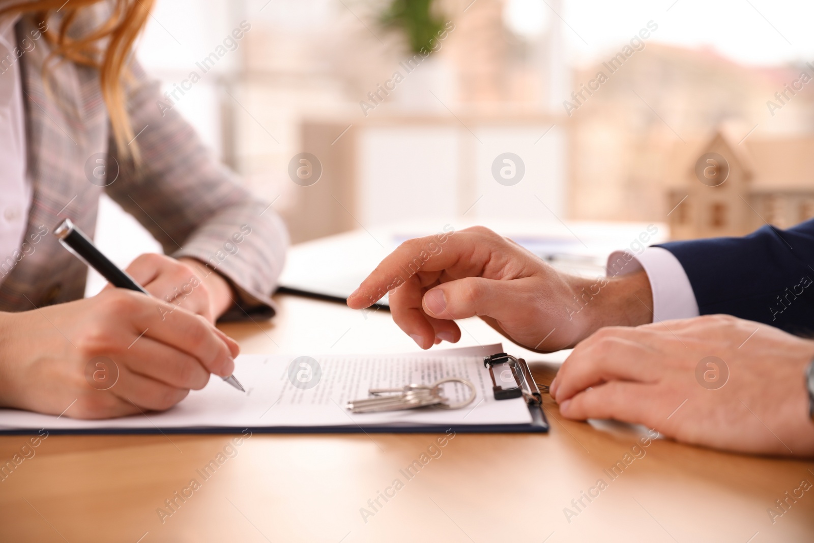 Photo of Real estate agent working with client in office, closeup