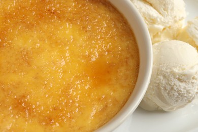 Photo of Delicious creme brulee and scoops of ice cream on plate, closeup