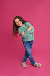 Photo of Full length portrait of cute little girl on pink background