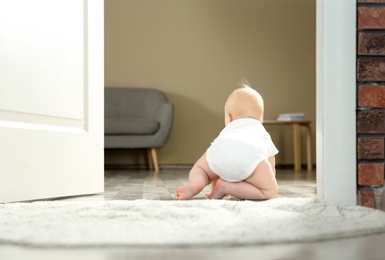 Cute little baby crawling on rug indoors, space for text