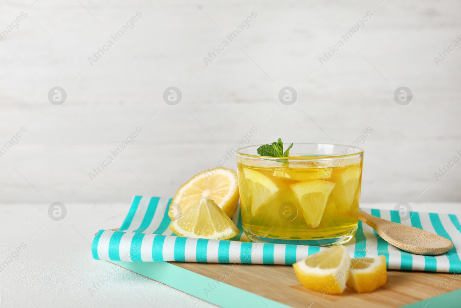 Photo of Glass of lemon jelly served on white table against light background. Space for text