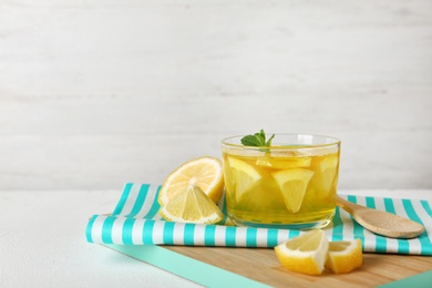 Photo of Glass of lemon jelly served on white table against light background. Space for text