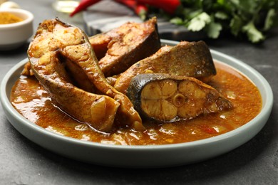 Photo of Tasty fish curry on grey textured table, closeup. Indian cuisine