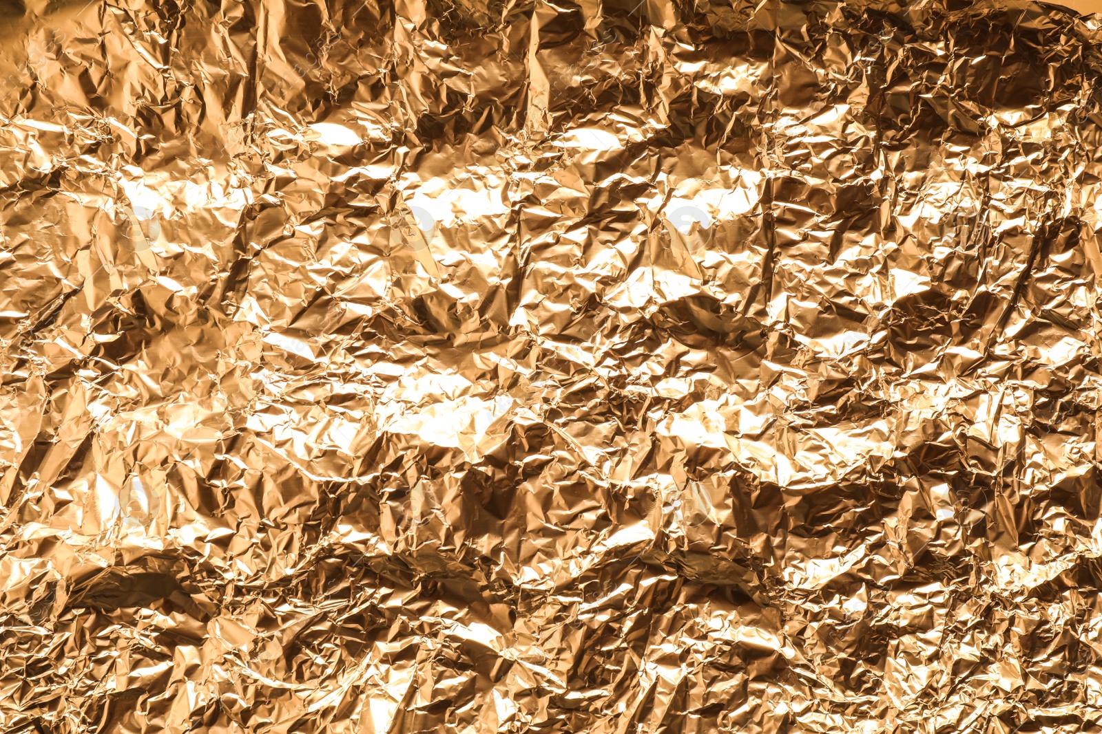 Photo of Crumpled gold foil as background, top view