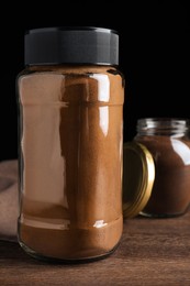 Jars of instant coffee on wooden table, closeup view