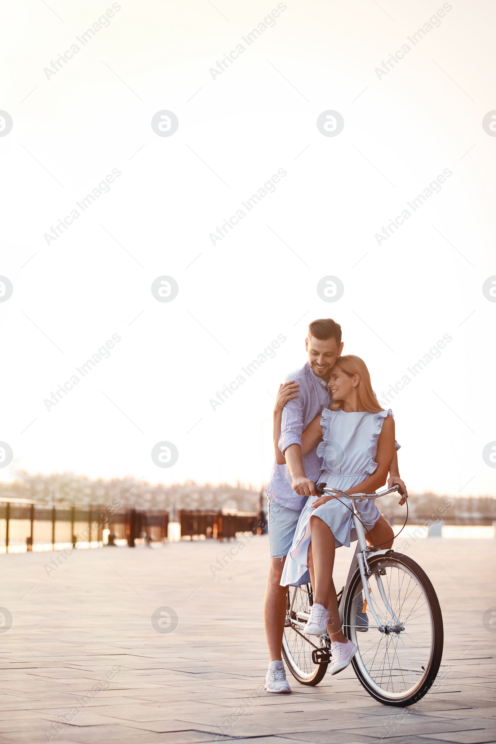 Photo of Happy couple riding bicycle outdoors on summer day