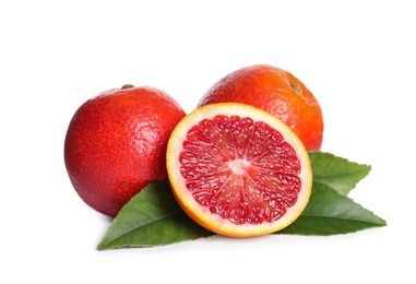 Photo of Whole and cut red oranges with green leaves on white background