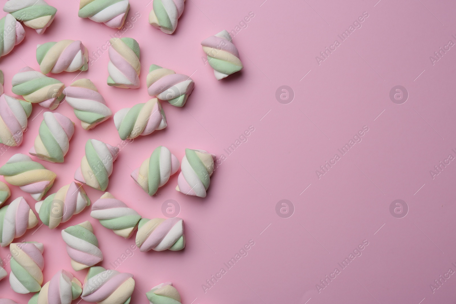 Photo of Delicious colorful marshmallows on pink background, flat lay. Space for text