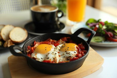 Photo of Tasty Shakshouka served on white table. Traditional Arabic dish