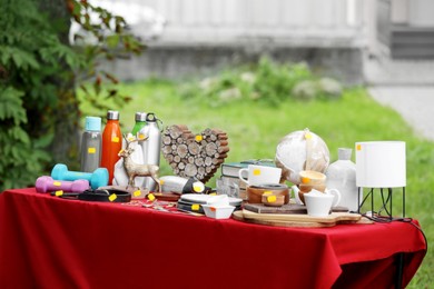 Photo of Different items on table in yard. Garage sale