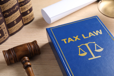 Tax law book and gavel on wooden table