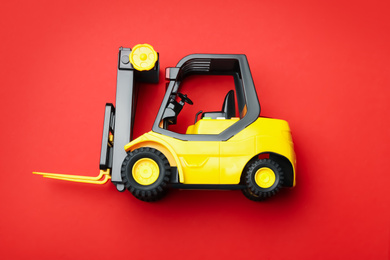 Photo of Top view of toy forklift on red background. Logistics and wholesale concept