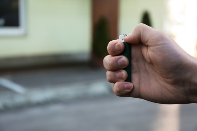 Photo of Man holding lighter outdoors, closeup. Space for text