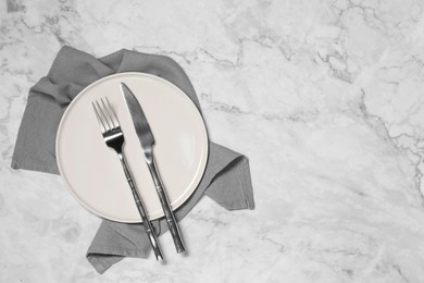 Photo of Stylish setting with elegant cutlery on white marble table, top view. Space for text