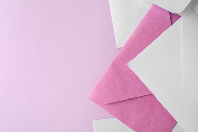 Photo of Colorful paper envelopes on pink background, flat lay. Space for text