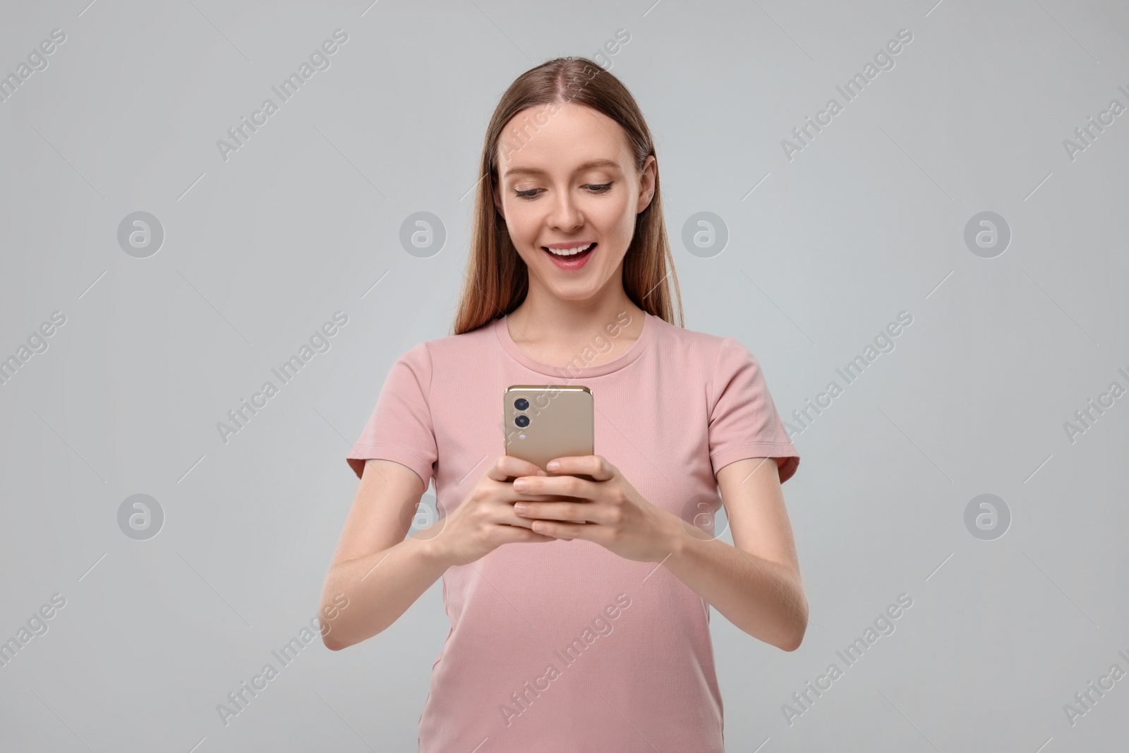 Photo of Woman sending message via smartphone on grey background, space for text