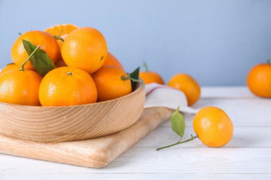 Photo of Fresh ripe tangerines on white wooden table