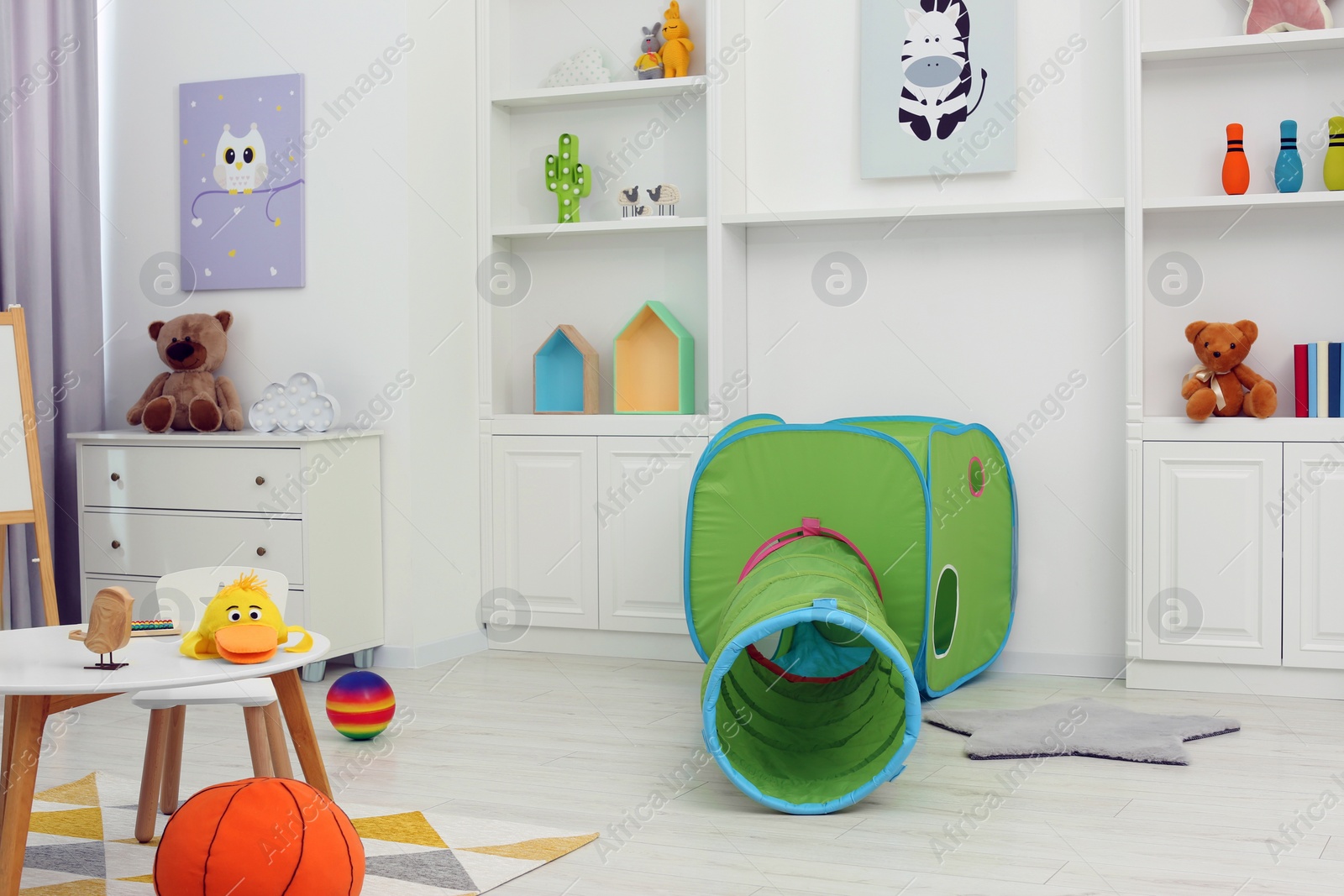 Photo of Child`s playroom with different toys and modern furniture. Stylish kindergarten interior