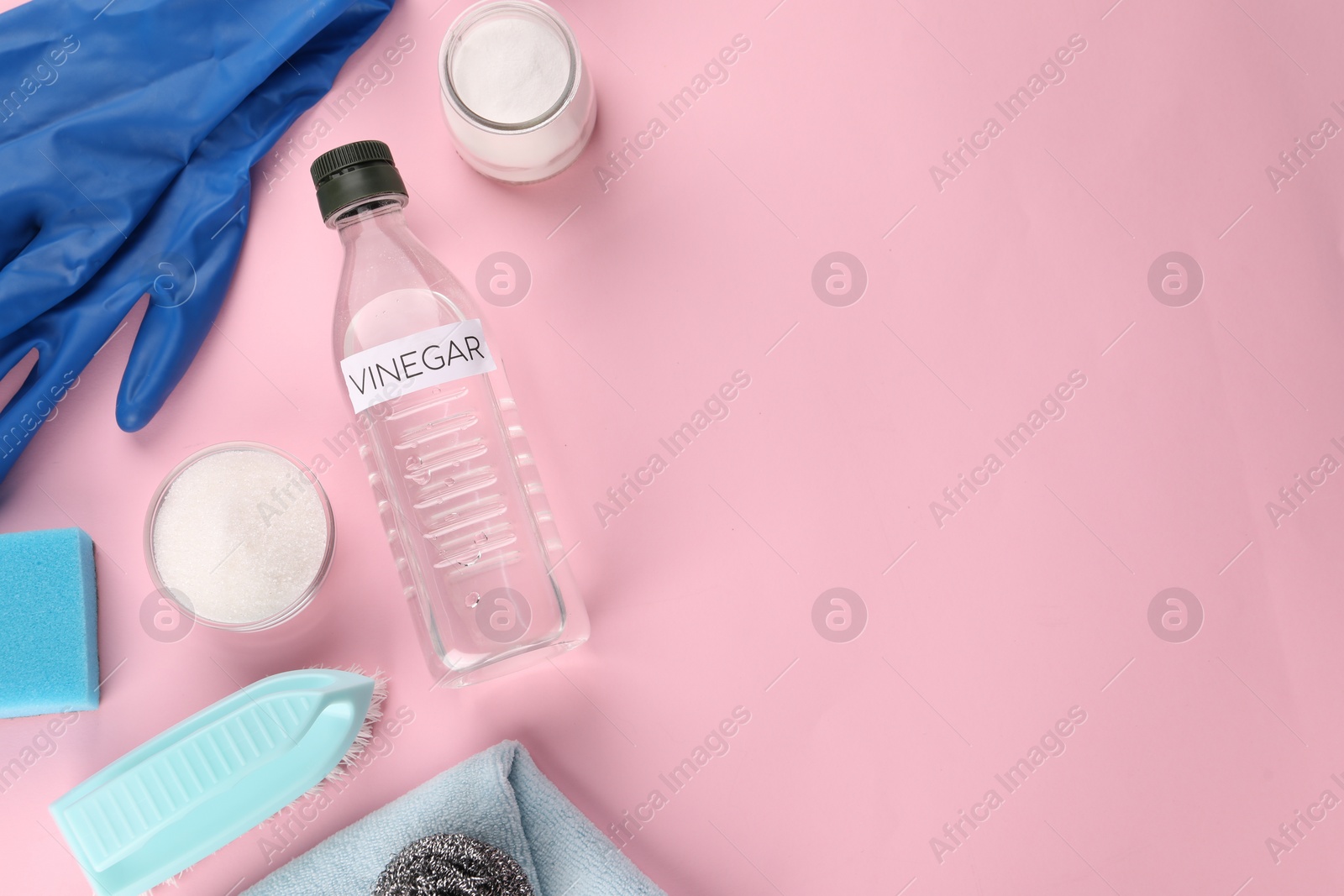 Photo of Eco friendly natural cleaners. Flat lay composition with bottle of vinegar on pink background, space for text