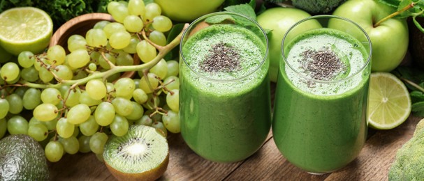 Image of Glasses of fresh green smoothie and ingredients on table. Banner design