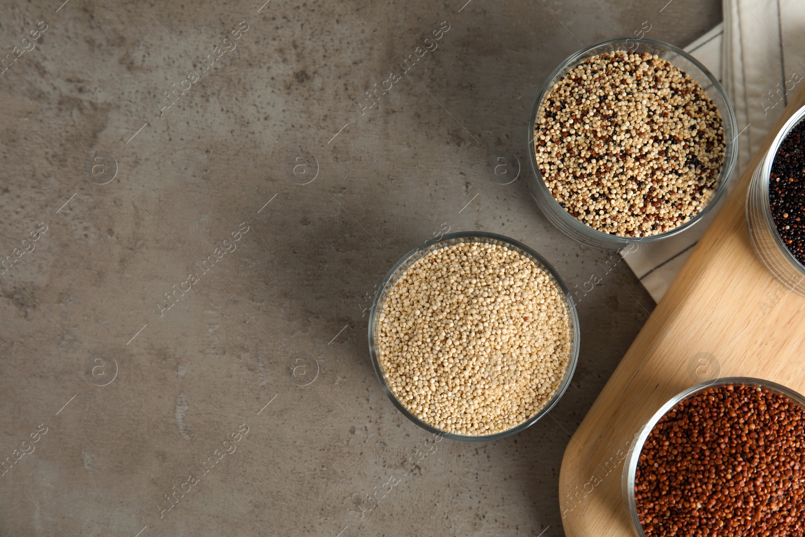 Photo of Flat lay composition with different types of quinoa and space for text on grey background